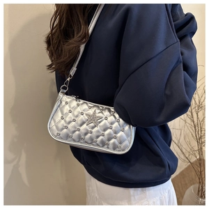 Detail of silver quilted crossbody bag featuring a rhinestone star and metal zipper