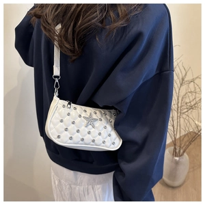 Close-up of a white quilted crossbody bag with sparkling rhinestones and star detail