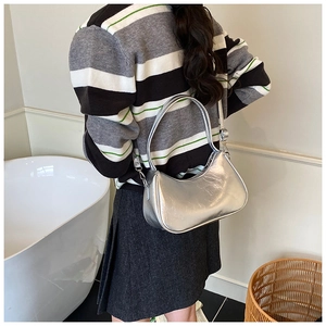 Détail du sac croissant argenté en similicuir texturé avec sa bandoulière réglable
