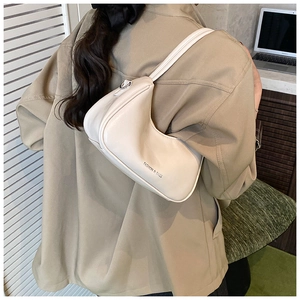Détail du sac crème avec logo Fashion & Bags porté sur une veste de couleur kaki