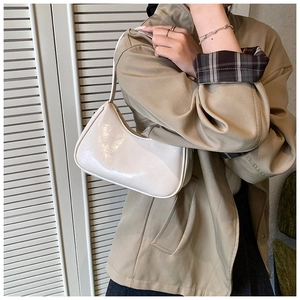 Gros plan du sac hobo blanc brillant en cuir verni sur un trench-coat kaki élégant