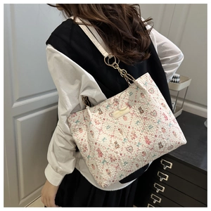 Detail of floral bear jacquard tote bag with golden chain and white leather shoulder strap