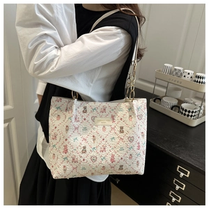 Close-up of floral tote bag featuring cute bear patterns and metal chain strap