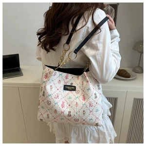 Detail of floral bear pattern tote bag with gold chain and black leather strap