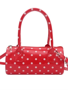 Chic red cylinder handbag with white polka dots and silver hardware for crossbody use