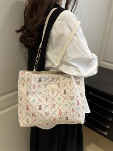 Quilted tote bag with cute cartoon prints and chain shoulder strap on model