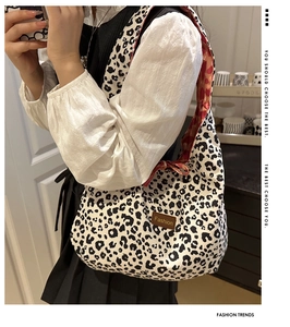 Detailed side view of bohemian leopard print tote bag featuring a leather fashion label