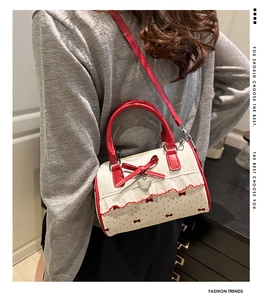 Detail of red and white polka dot Boston bag featuring lace trim and bow accent