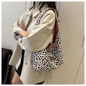 Detail of leopard print tote bag featuring black and white pattern and Fashion leather label