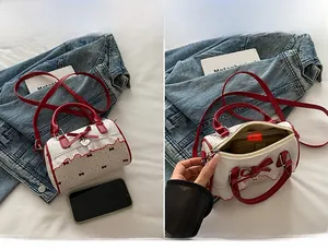 Internal capacity view of small Boston bag with red polka dots and bow detail