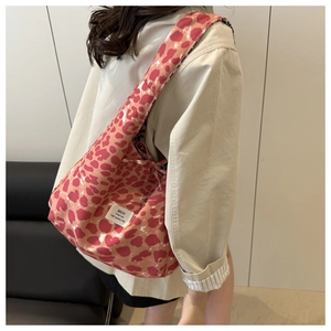 Detail of pink leopard print canvas tote bag featuring white woven label on side