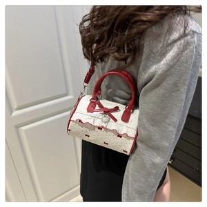 Détail du pendentif cœur sur sac à pois avec bordure en dentelle et nœud rouge