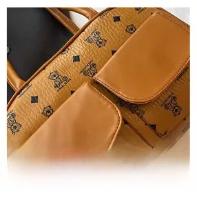 Macro detail of brown textured leather bag with bear patterns and dual front flap pockets