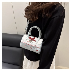 Borsa Boston blu e bianca con fiocco rosso e pizzo indossata da una modella