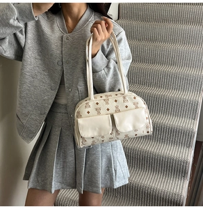Detail of cream Boston bag with bear pattern and symmetrical front flap pockets