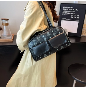 Detail of a black printed Boston bag with bear patterns and dual front flap pockets