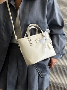 Sac seau élégant en similicuir crème avec nœud en dentelle et pendentif perle sur mannequin