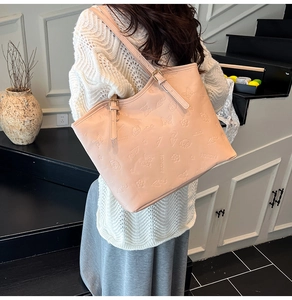 Detail of light pink tote bag with floral embossed pattern and long shoulder strap