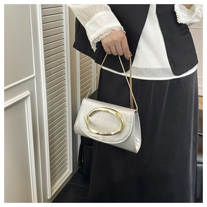 Close-up of silver pearlescent evening bag with a large polished gold oval buckle