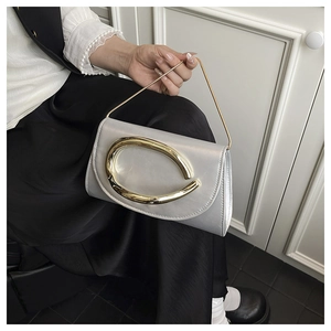 Detail of silver metallic evening bag with gold C-buckle and elegant chain handle