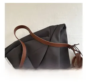 Detailed view of the brown leather handle on a woven beach tote bag for summer