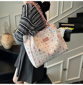 Détail d'un sac cabas floral avec des anses en corde tressée rose et motif d'ours