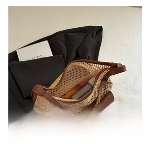 Detail view of large straw tote bag interior space showing daily items and leather trim
