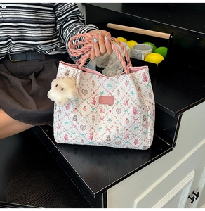 Détail du cabas blanc aux motifs d'animaux roses avec porte-clé mouton peluche