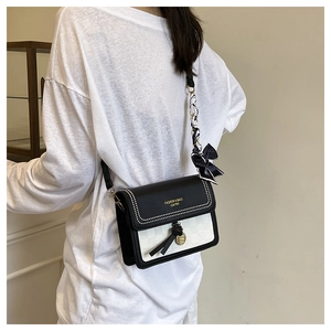 Detail view of contrast square crossbody bag with woven texture and silk scarf bow