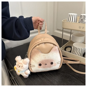 Detail view of mini cat backpack with soft suede texture and plush bunny charm