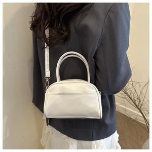 Détail du sac à main blanc en similicuir avec double poignée et accents dorés chic