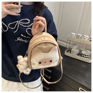 Close-up of cute cartoon backpack with cat plush pocket and fluffy bunny charm detail