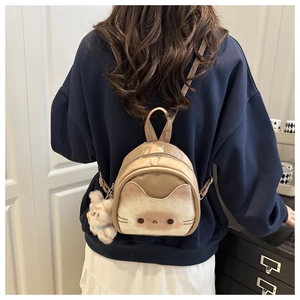 Detail of cute cat-themed mini backpack with fluffy rabbit pendant on adjustable strap
