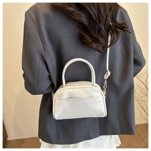 Detail of cream white PU leather handbag featuring gold hardware and detachable strap