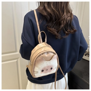 Detail view of a beige mini cat-shaped backpack with textured 3D kitten face design