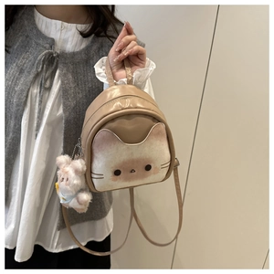 Detail of cute cat backpack with white plush bear charm and adjustable straps