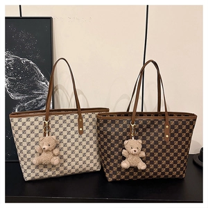 Detailed view of tote bags with checkerboard patterns and cute plush bear charms