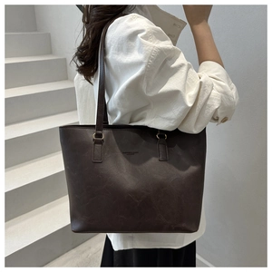 Λεπτομέρεια vintage καφέ τσάντας tote με υφή δέρματος και λουράκι ώμου σε μοντέλο