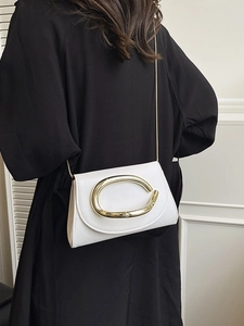 Elegant white leather crossbody bag with a large gold oval buckle shown on a model