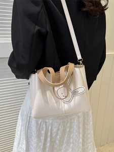 Minimalist beige PU leather tote bag with brown handles and a cute rabbit charm detail