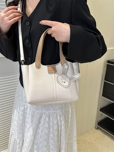 Elegant cream tote bag with rabbit charm and khaki handles for daily work use