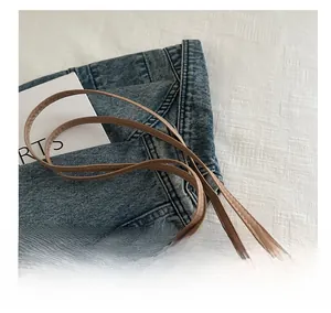 Detail of comfortable brown faux leather handle with white stitching on crossbody bag