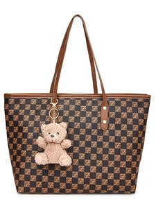 Brown checkered large tote bag with leather handles and a plush bear pendant on white background