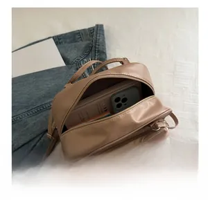 Detail view showing interior capacity for a smartphone and notebook in a cat-themed backpack