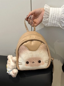Cute beige cat-themed mini backpack with fluffy pom-pom charm and top handle strap