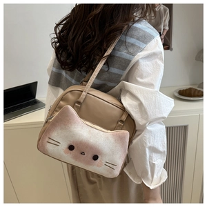 Detail of cute cat shaped front pocket on khaki faux leather shoulder bag with plush texture