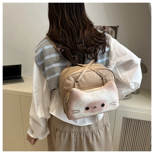 Detail of cute cat-shaped front pocket on khaki faux leather tote bag with plush texture