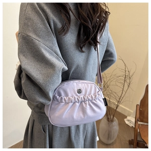 Detail of lavender purple crossbody bag featuring front pleats and metallic M logo