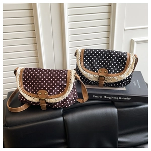 Detail of retro polka dot canvas bags with lace trim and leather straps in two colors