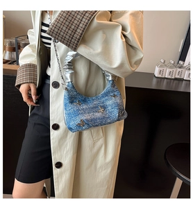 Détail du sac à main bleu avec papillon en métal et poignée nuage plissée argentée